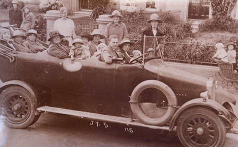 Sepia photograph of an open charabanc full of passengers in hats on an outing