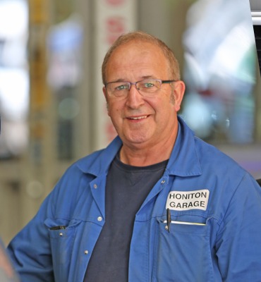 Senior mechanic in blue Honiton Garage overalls in the workshop