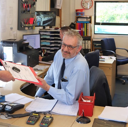 Our reception desk, a member of the team handing back paperwork with a smile