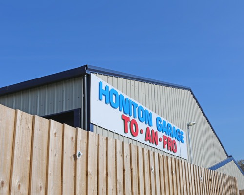 Our building sign, Honiton Garage To-An-Fro, against a blue sky